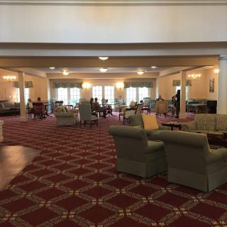 A spacious lounge area with comfortable seating and elegant carpeting.