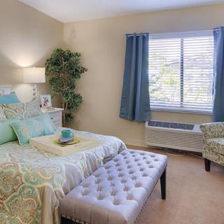 A cozy and well-decorated bedroom featuring a comfortable bed, soft lighting, and elegant curtains.