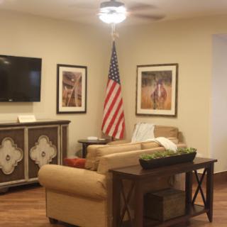 A cozy living room featuring an American flag and art on the walls.