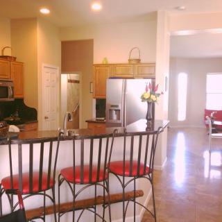 Modern kitchen with bar stools and an open layout.