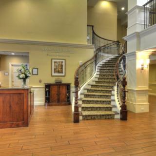A spacious hotel lobby featuring a grand spiral staircase and a reception desk.