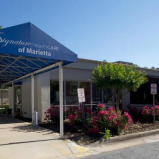 An information center with a blue awning and landscaped flowers in front.