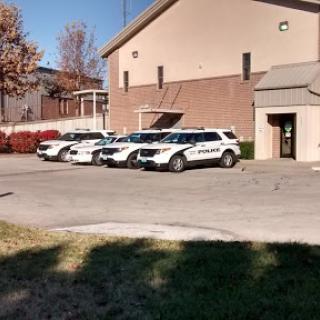 A row of police vehicles parked outside a law enforcement building.
