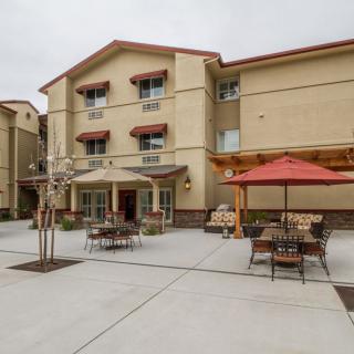 A residential building with outdoor patio seating and umbrellas.