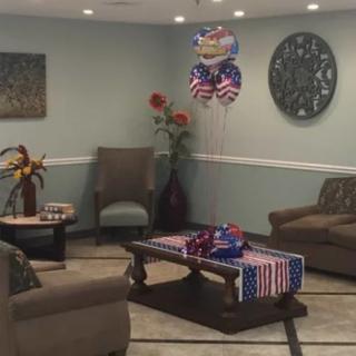 A cozy living room decorated with colorful balloons and arranged with comfortable seating.