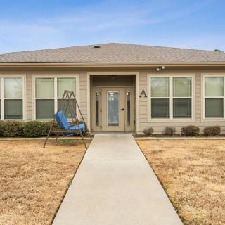A single-story house with a swing chair on the porch and a neatly paved walkway leading to the entrance.