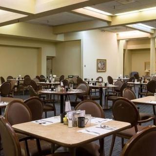 An empty restaurant dining area with neatly arranged tables and chairs.