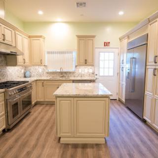 A modern kitchen featuring elegant cabinetry, a central island, and bright lighting.