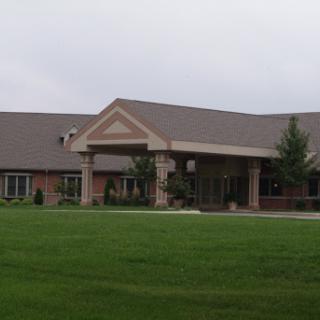 A modern building surrounded by a grassy area, featuring a welcoming entrance.