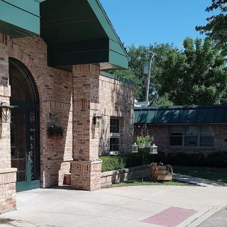 A well-designed brick building featuring a distinct entrance and surrounded by greenery.
