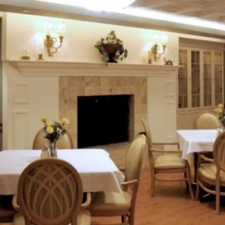 An elegant dining room with a fireplace and neatly arranged tables and chairs.