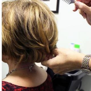 A woman receiving a haircut at a salon.