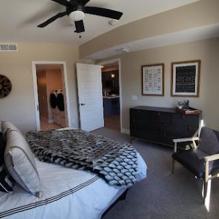 A cozy and modern bedroom featuring a neatly made bed, stylish furniture, and decorative artwork on the walls.