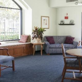 A cozy living room with a sofa, armchair, and window seat.