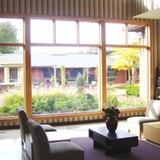A modern living room with large windows overlooking a garden.