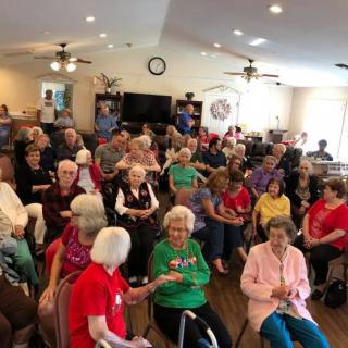 A group of seniors gathered indoors for a community event.