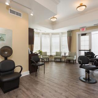 A modern salon interior with a waiting area and styling chairs.