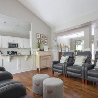 A modern open space living room with comfortable seating and a view into the kitchen.