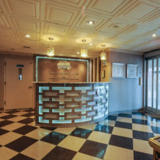 A modern hotel reception area with a checkered floor and contemporary design elements.