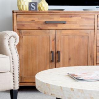 A cozy living room featuring a wooden cabinet, a plush chair, and a round coffee table.
