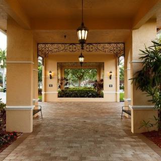 A covered entrance with hanging lanterns and potted plants on either side.