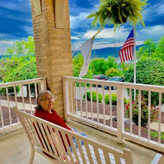 A peaceful moment on the porch with a beautiful view and gentle clouds overhead.