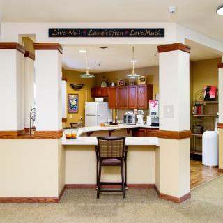 A welcoming kitchen area with a counter and chair, featuring modern appliances.