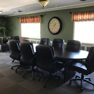 A spacious conference room equipped with a large table and comfortable seating, perfect for meetings.