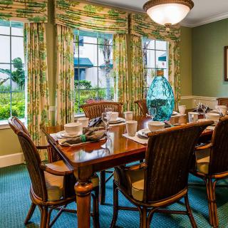 A beautifully set dining room with large windows and elegant decor.