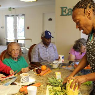 A group of people in a community kitchen participating in a cooking activity.