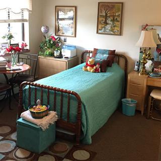 A cozy bedroom with a teal color scheme, featuring a single bed, decorations, and warm decor.