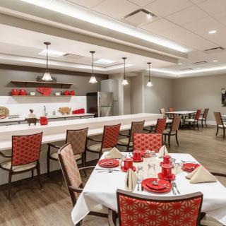 A well-decorated dining area with neatly arranged tables and red accents.