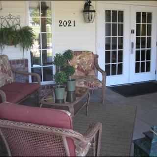A cozy outdoor seating area at the entrance of a house, perfect for relaxation.