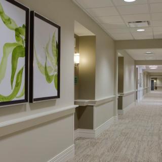 A modern hallway featuring abstract artwork and contemporary lighting.