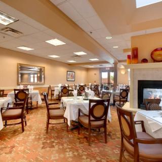 An inviting restaurant dining area with neatly arranged tables, elegant chairs, and a cozy fireplace.