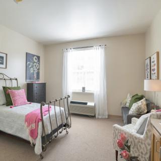 A bright and cozy bedroom featuring a vintage bed, soft pastel decor, and natural light streaming through the window.