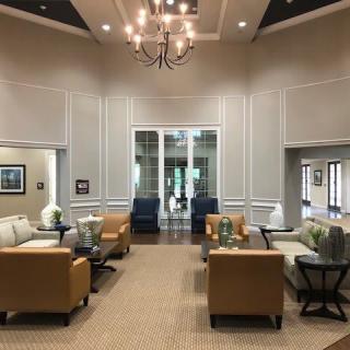 A spacious and elegant lobby with comfortable seating and a central chandelier.
