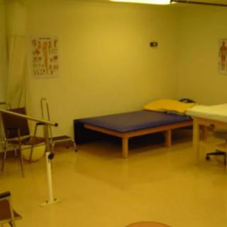 A rehabilitation room equipped with therapy beds and medical equipment for physical therapy sessions.