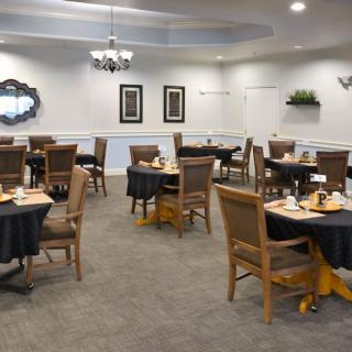 Elegant dining room setup with neatly arranged tables and chairs.