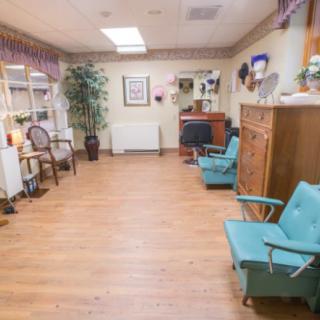 A cozy salon waiting area with vintage chairs, wooden flooring, and decorative elements.