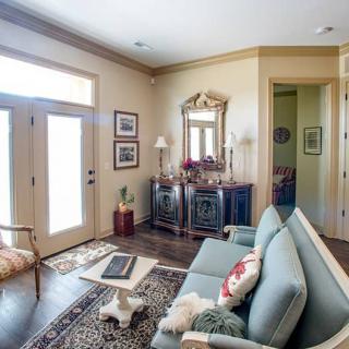 A cozy living room featuring a sofa, decorative rug, and an ornate mirror on the wall.