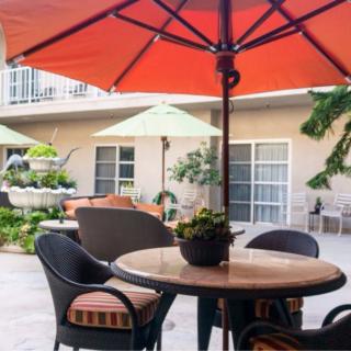 A cozy outdoor patio area with tables, chairs, and large umbrellas.
