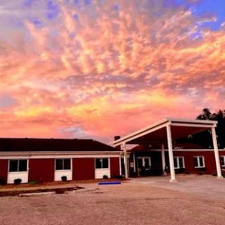 A stunning sunset casts vibrant colors across the sky above a charming building.