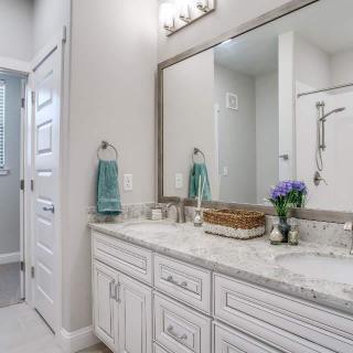A modern bathroom with a large mirror, double sinks, and elegant decor.