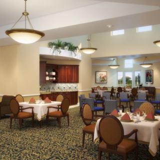 A spacious and elegantly furnished dining area with round tables and soft lighting.