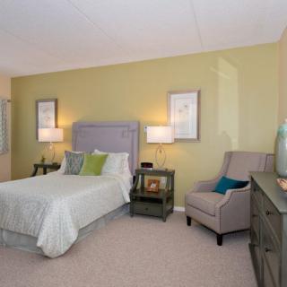 A modern bedroom with a comfortable bed, stylish furniture, and soft lighting.
