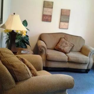 A comfortable living room with sofas, a lamp, and decorative accents.
