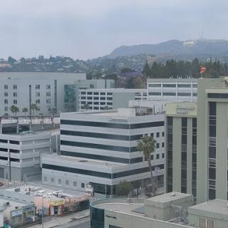A view of a modern urban landscape with buildings and distant mountains.