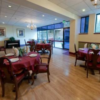 A cozy restaurant dining area with elegant tables and chairs, featuring ambient lighting.