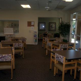 An empty community dining area with several tables and chairs arranged neatly.
